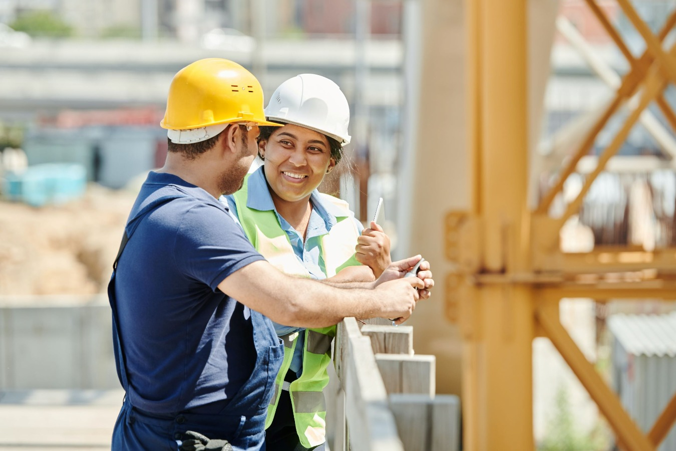 Male and female construction workers in conversation. 