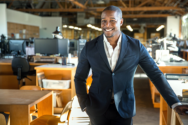Business owner standing in front of restaurant.